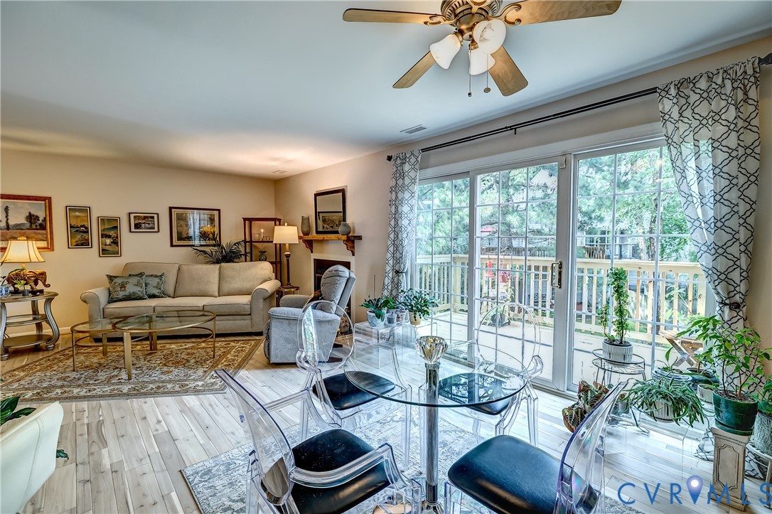 Living and dining area with a fireplace, glass table, and sliding doors to a deck.