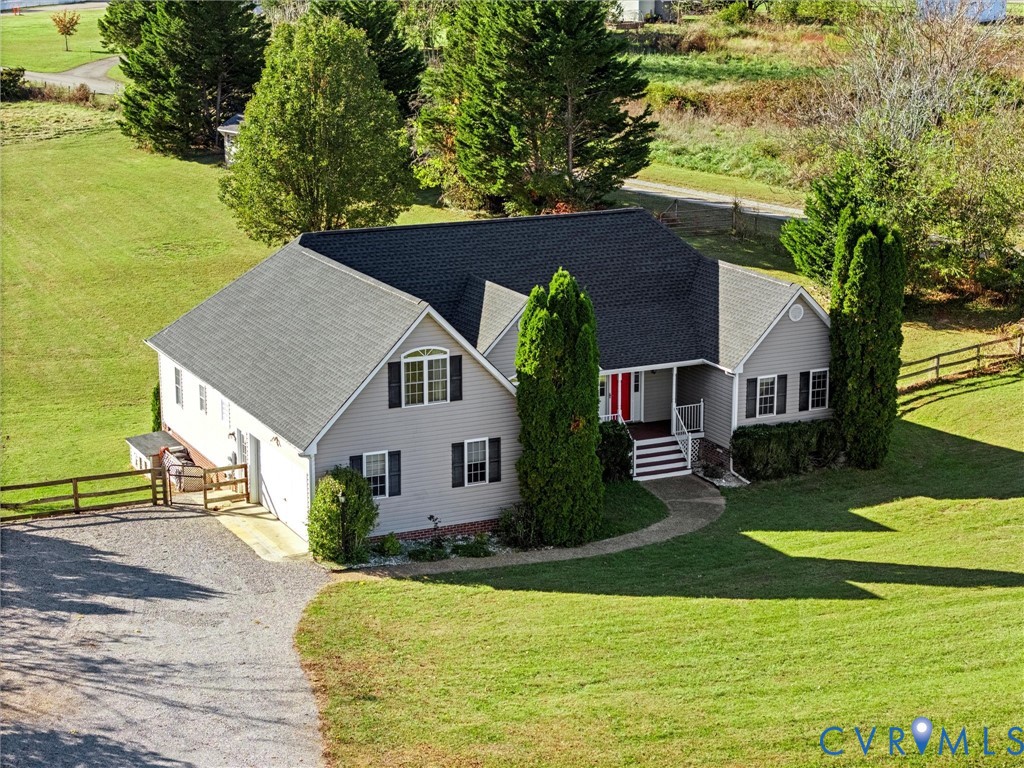 Gray single-story home with a red front door, curved walkway, and broad green lawn.