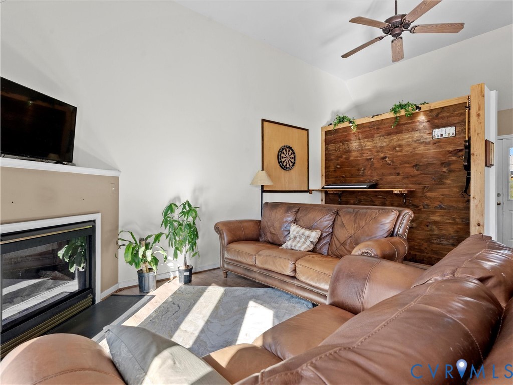 Living room with leather sofas, a fireplace, and a rustic wood accent wall.