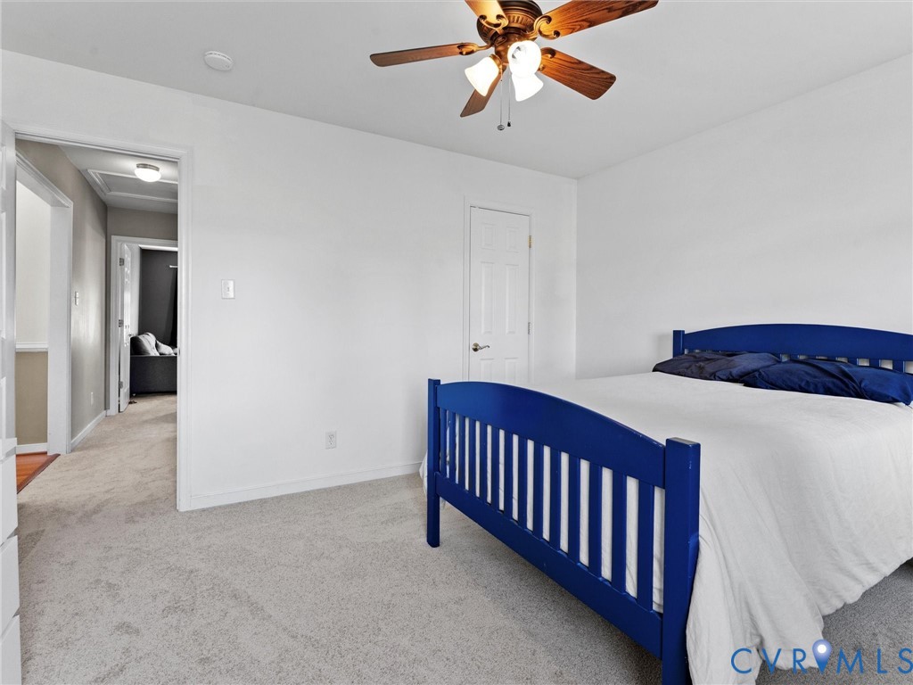Bedroom with a blue bed frame, white bedding, and a wood-blade ceiling fan.