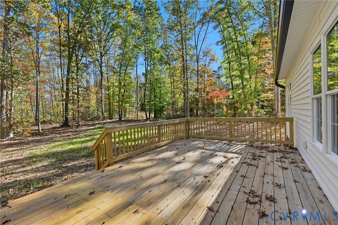 Wooden deck beside the house, overlooking a leafy wooded yard.