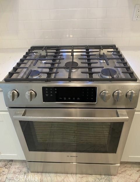 Stainless steel Bosch gas range with multiple burners and a black control panel.