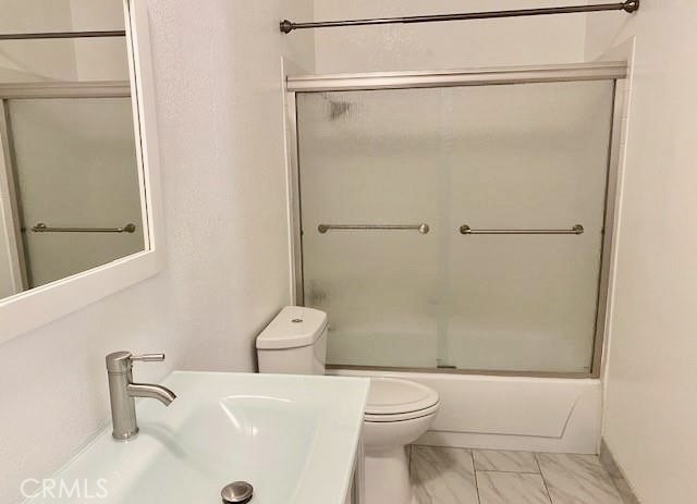 Bathroom with a glass-enclosed tub and shower, toilet, and marble-patterned floor.