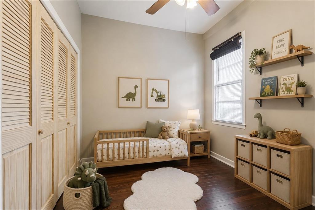 Nursery with a wooden toddler bed, dinosaur decor, floating bookshelves, and a cloud-shaped rug.