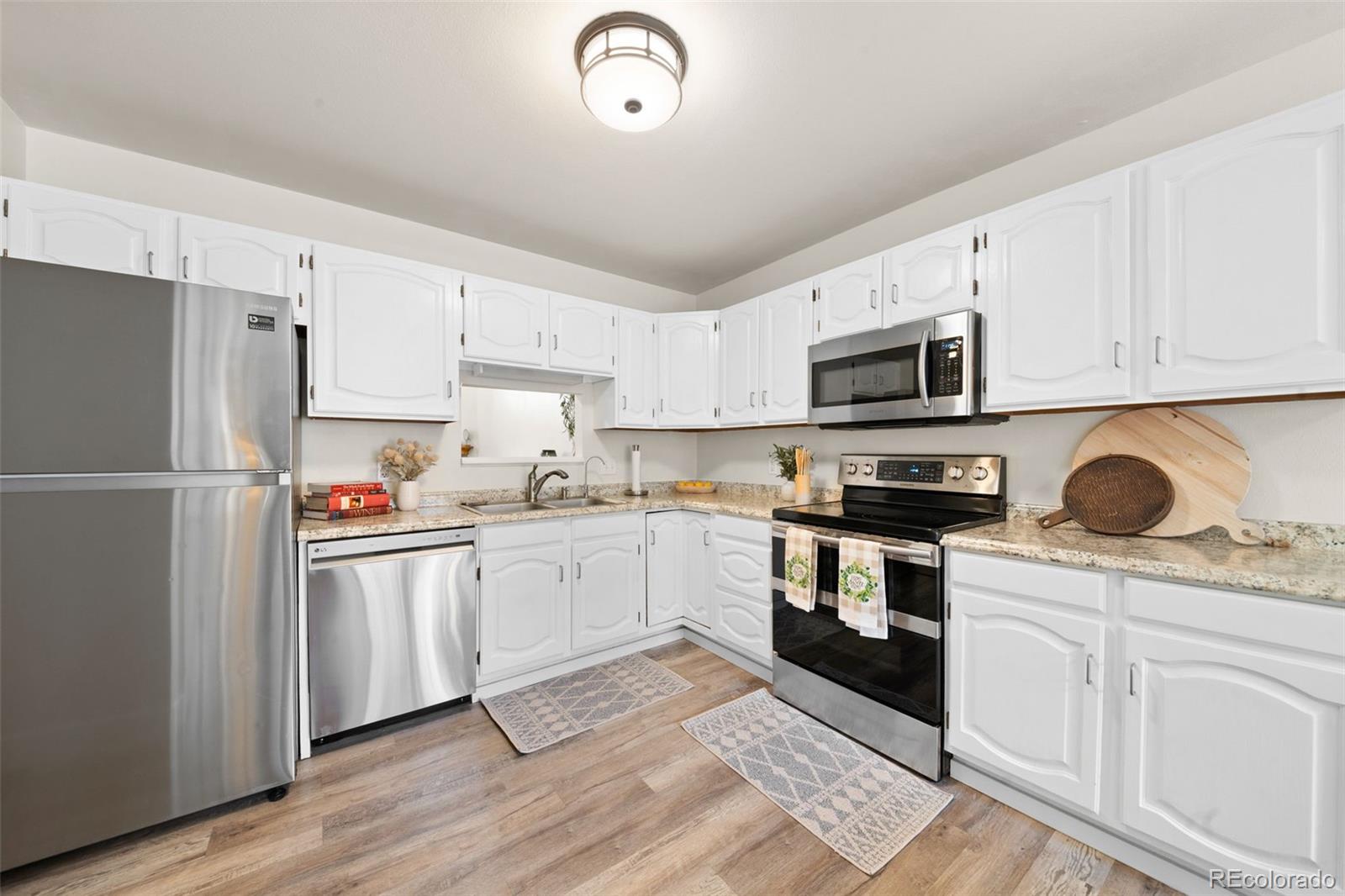 Kitchen with white cabinets, granite counters, and stainless steel appliances.