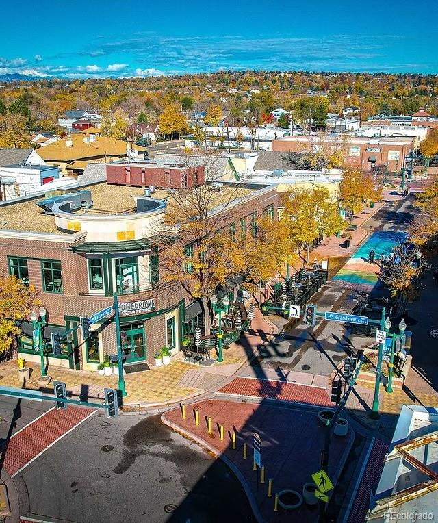 Elevated view of a commercial district with autumn trees and mountains in the distance.
