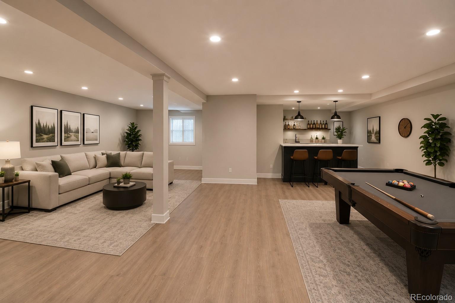 Basement recreation room with a sectional sofa, bar, and pool table.