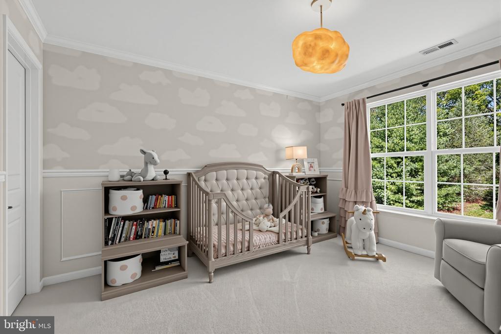 Nursery with a tufted crib, cloud-patterned wallpaper, and large windows overlooking trees.