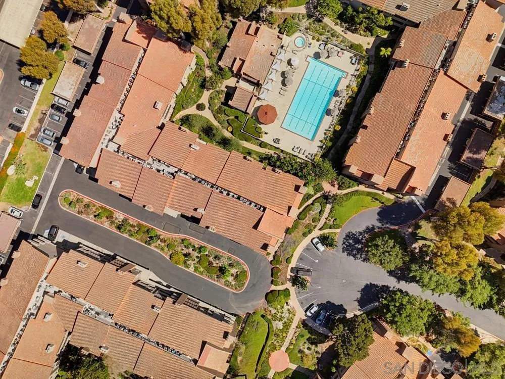 Aerial view of a condominium complex surrounding a courtyard pool and spa.