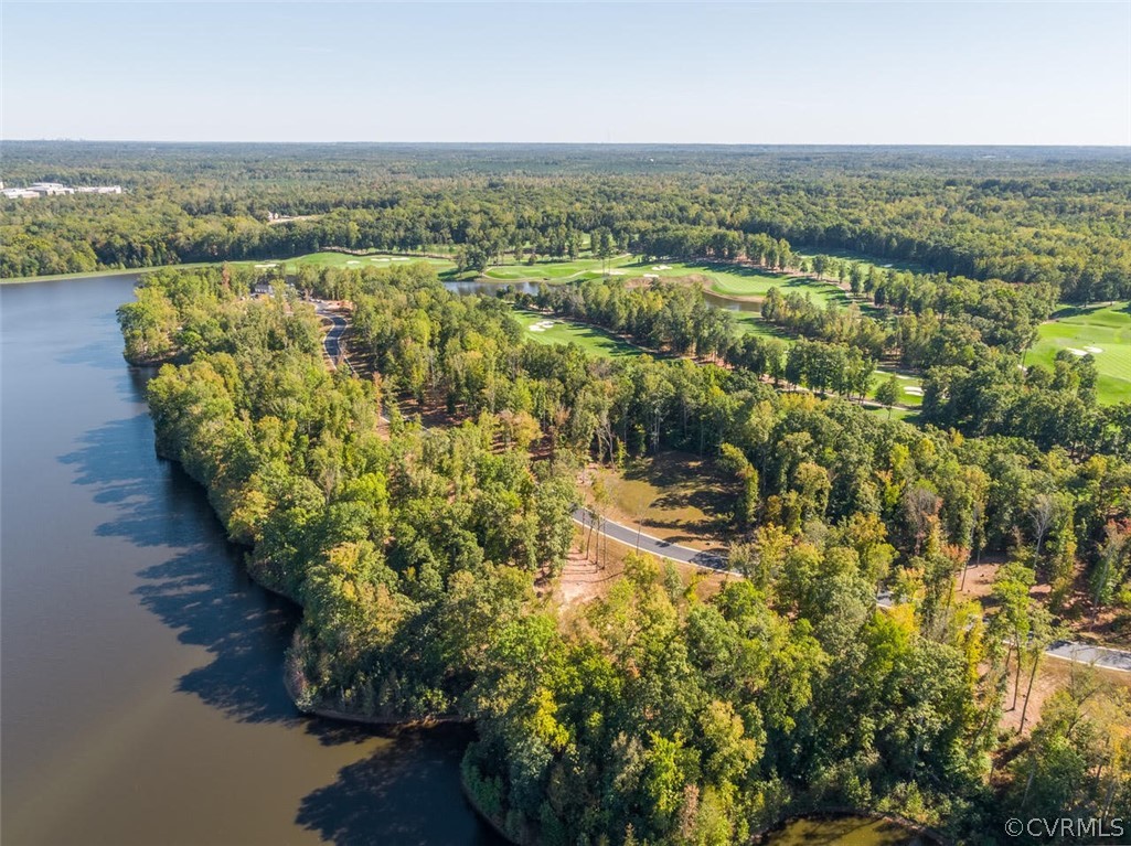 Aerial view of wooded lakeside property beside a golf course.