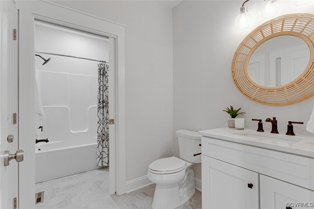 Bathroom with a white vanity and round rattan-framed mirror beside a bathtub.
