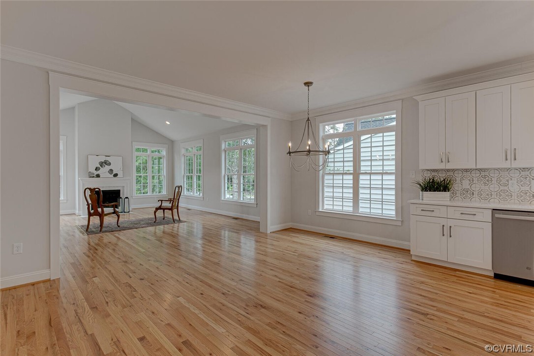 Open dining area with hardwood floors, white cabinetry, and an adjoining sitting area by the fireplace.