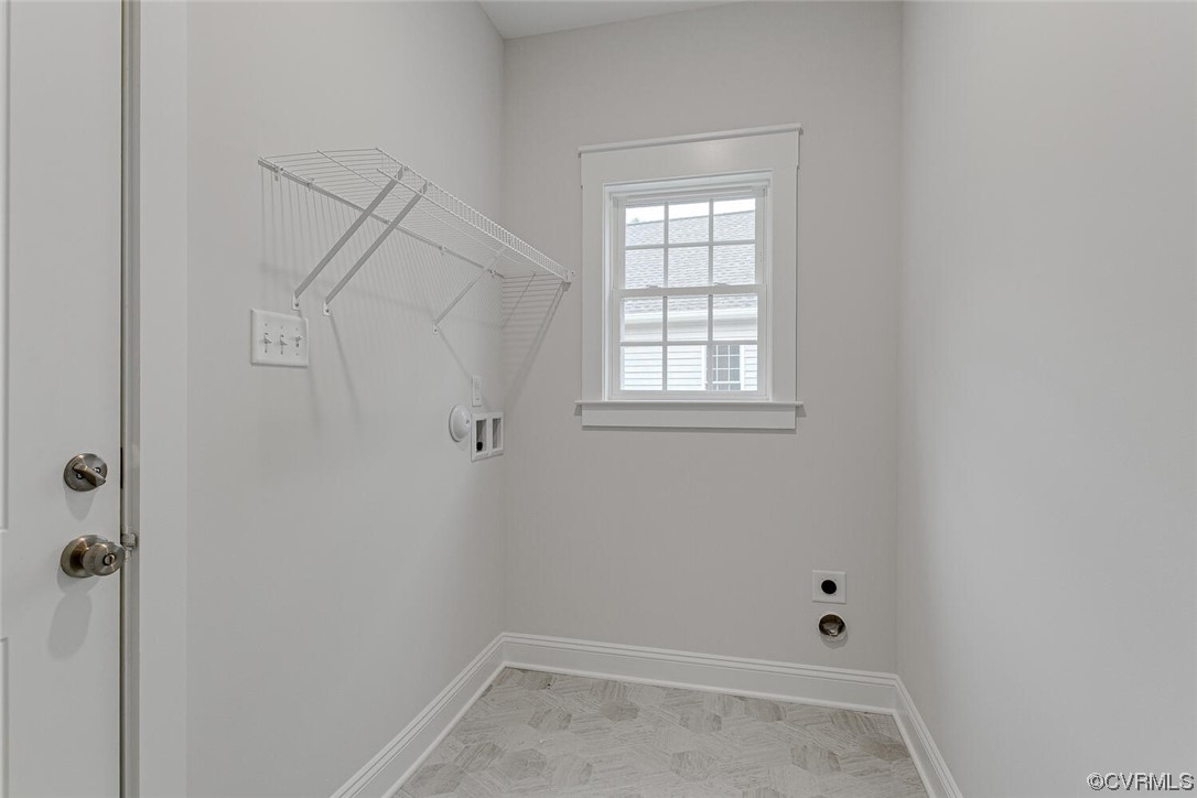 Empty laundry room with wire drying racks, hookups, and a small window.