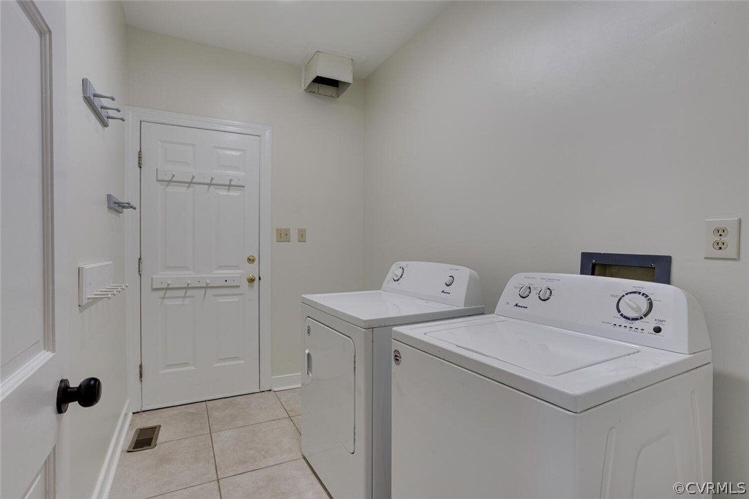 Laundry room with white washer and dryer beside a paneled door.