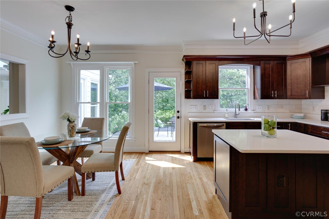 Kitchen with a large white island, dark wood cabinets, and an adjoining glass-table dining area.