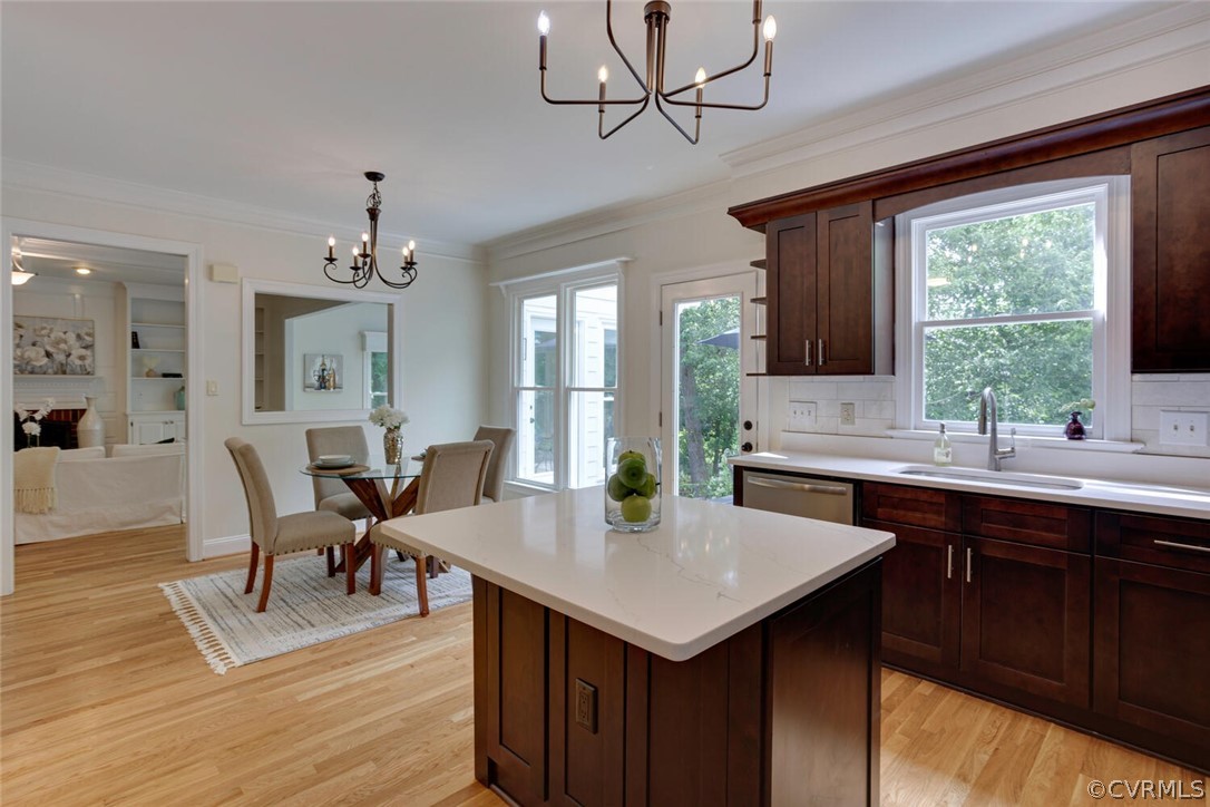 Kitchen with a large white island, dark wood cabinets, and an adjoining dining area.