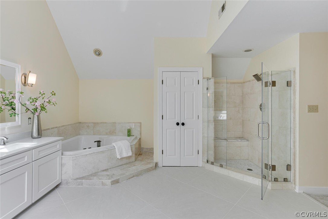 Primary bathroom with a corner soaking tub and a glass-enclosed tiled shower with a built-in bench.