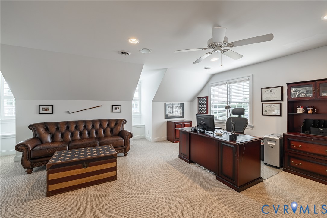 Furnished home office with a dark wood desk, leather sofa, and star-patterned chest.