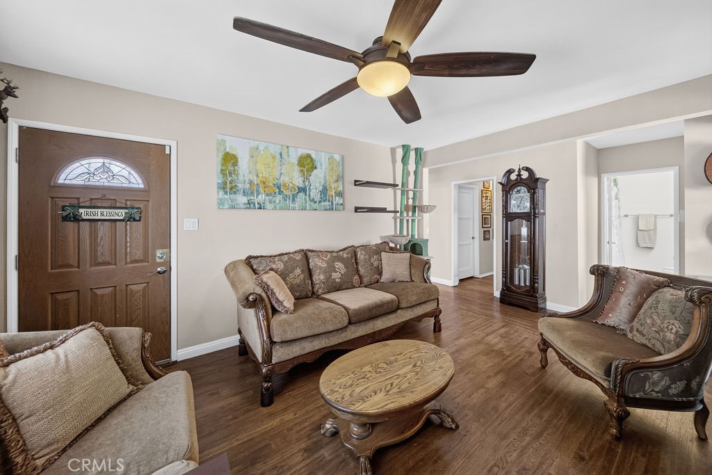 Living room with beige seating, an oval wood coffee table, and a grandfather clock.