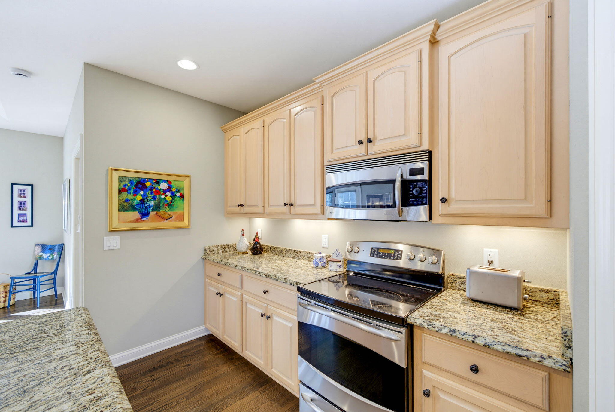 Kitchen with light wood cabinets, granite counters, and stainless steel appliances.