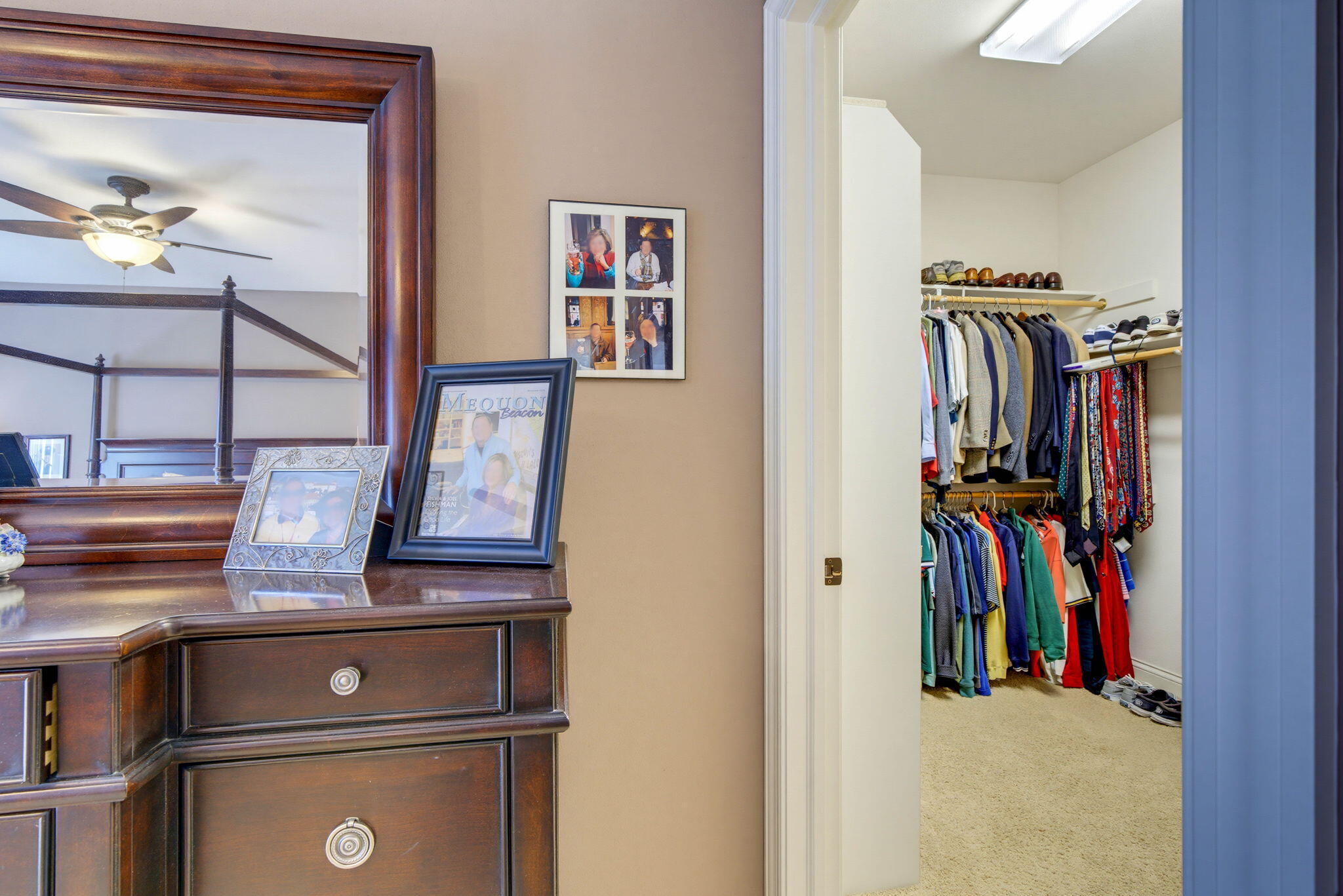 Bedroom dresser and mirror beside a walk-in closet filled with clothes and shoes.