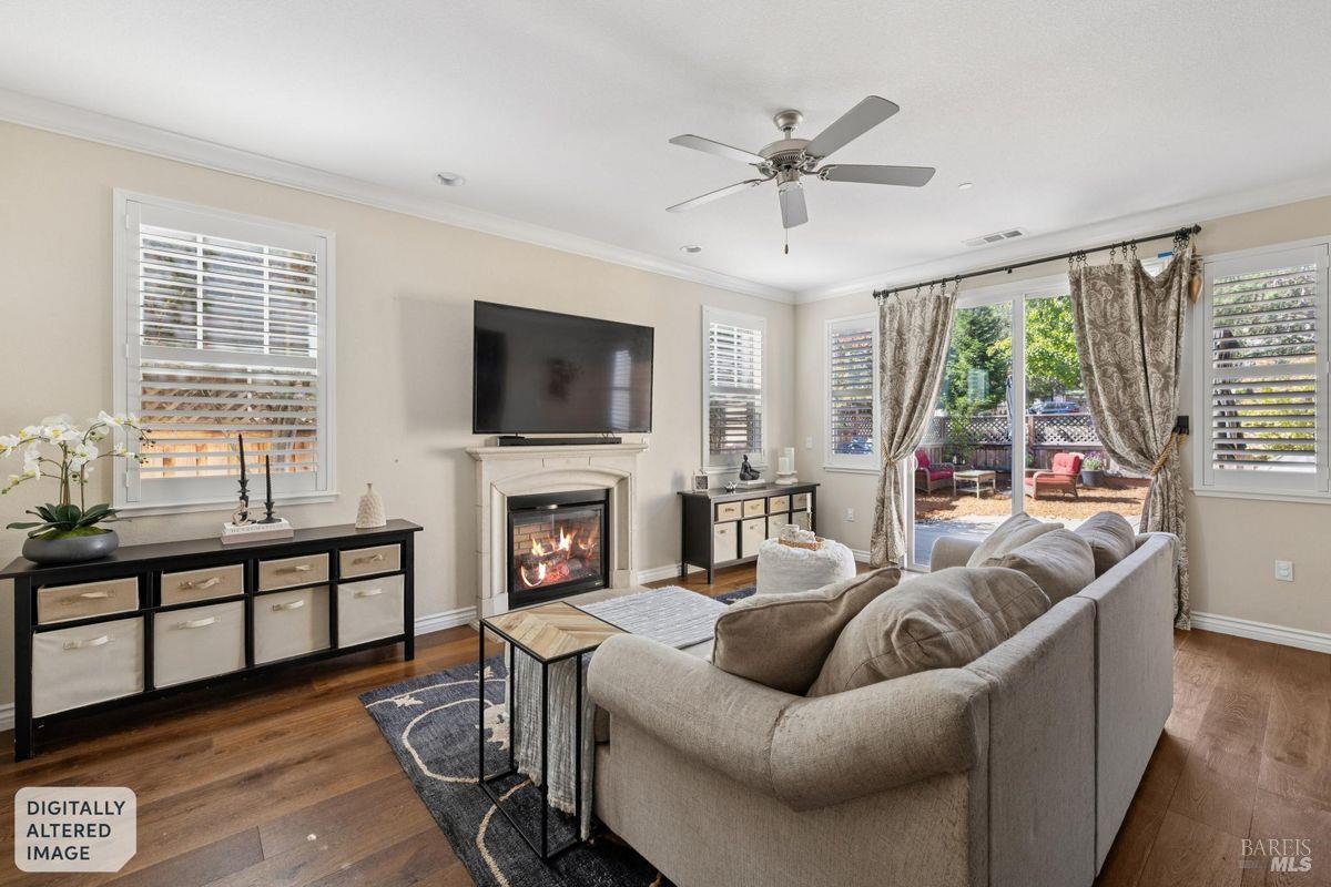 Living room with a fireplace, large sectional sofa, hardwood floors, and sliding glass doors to a patio.