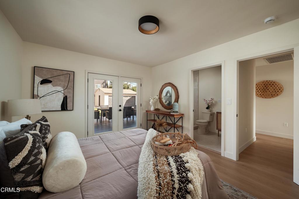 Bedroom with a quilted bed, woven throw, and glass doors opening to a patio.