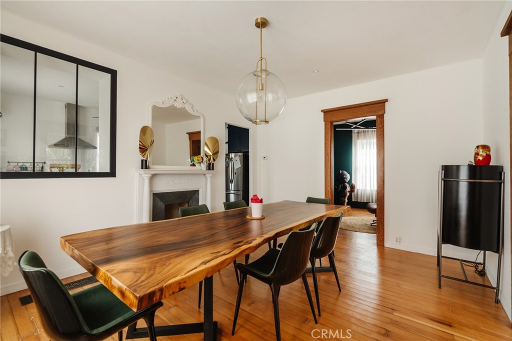 Dining room with a live-edge wood table, dark chairs, and white fireplace.
