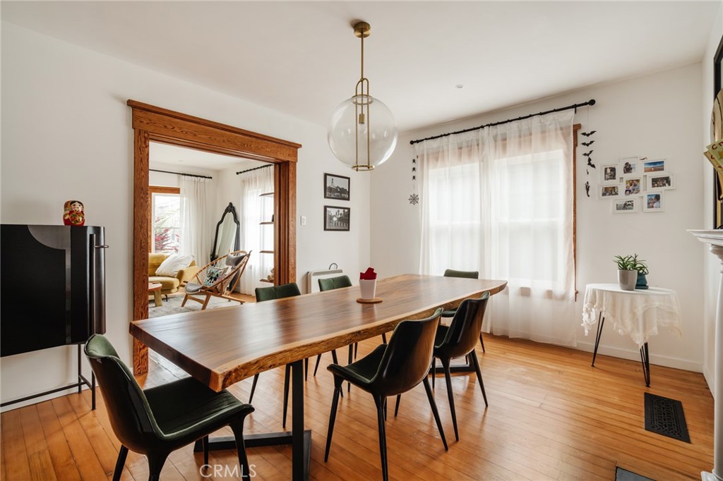 Dining room with a long wooden table, dark chairs, and a wide carved-wood doorway
