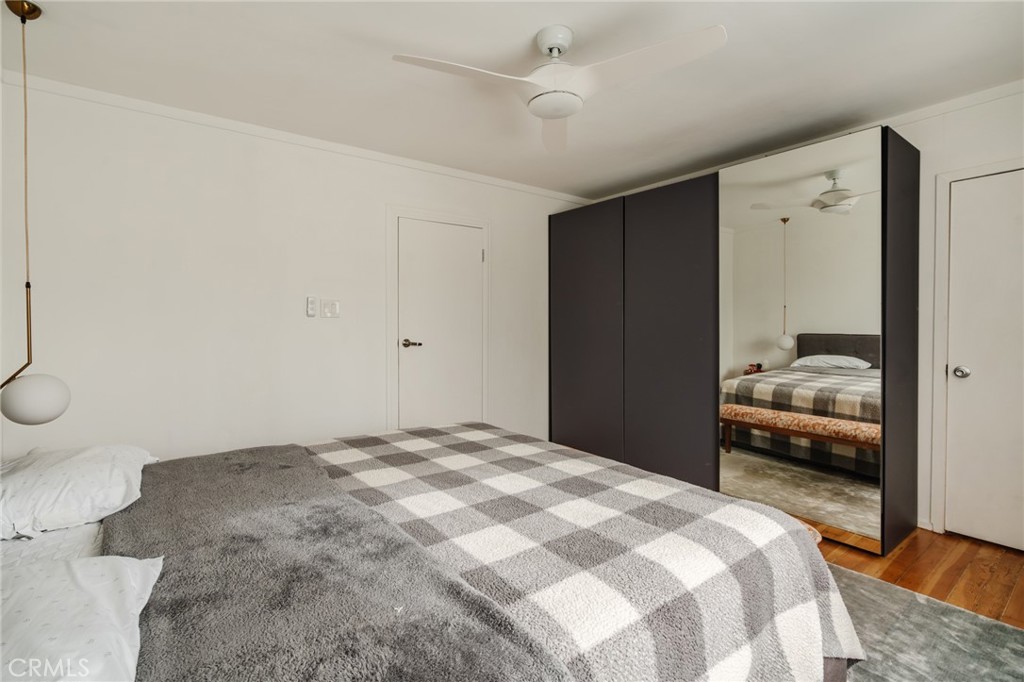Bedroom with a checkered bedspread and dark mirrored wardrobe.