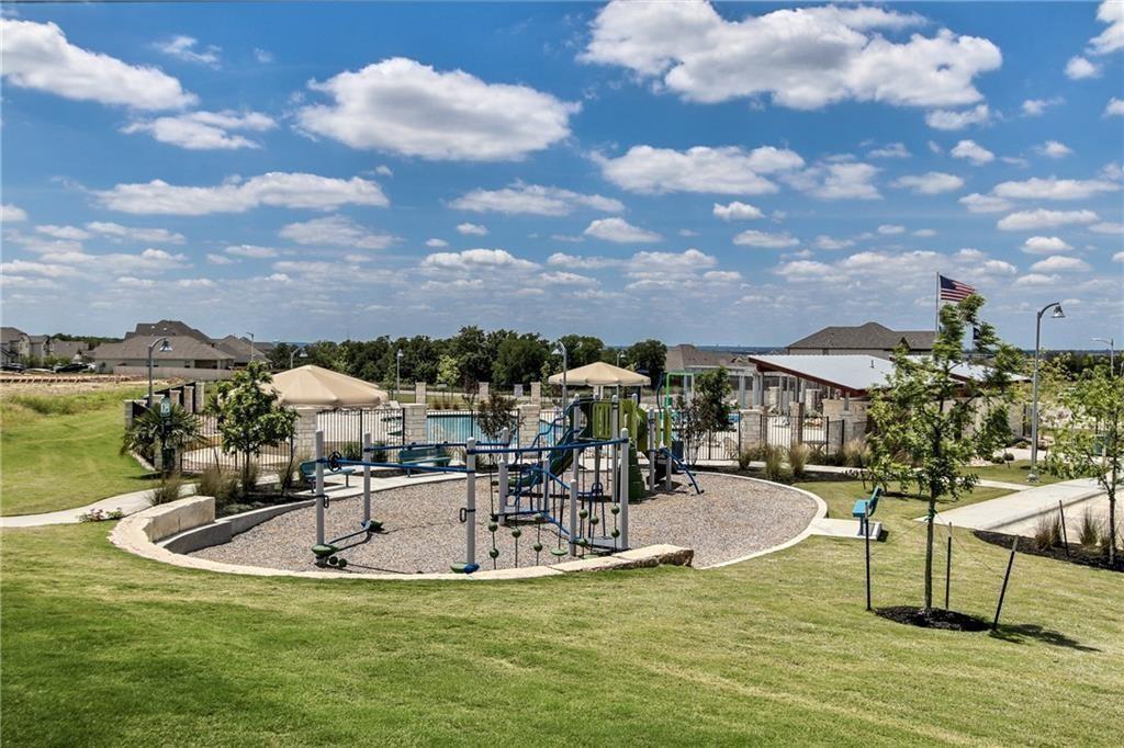 Community playground and swimming pool surrounded by landscaped lawns.