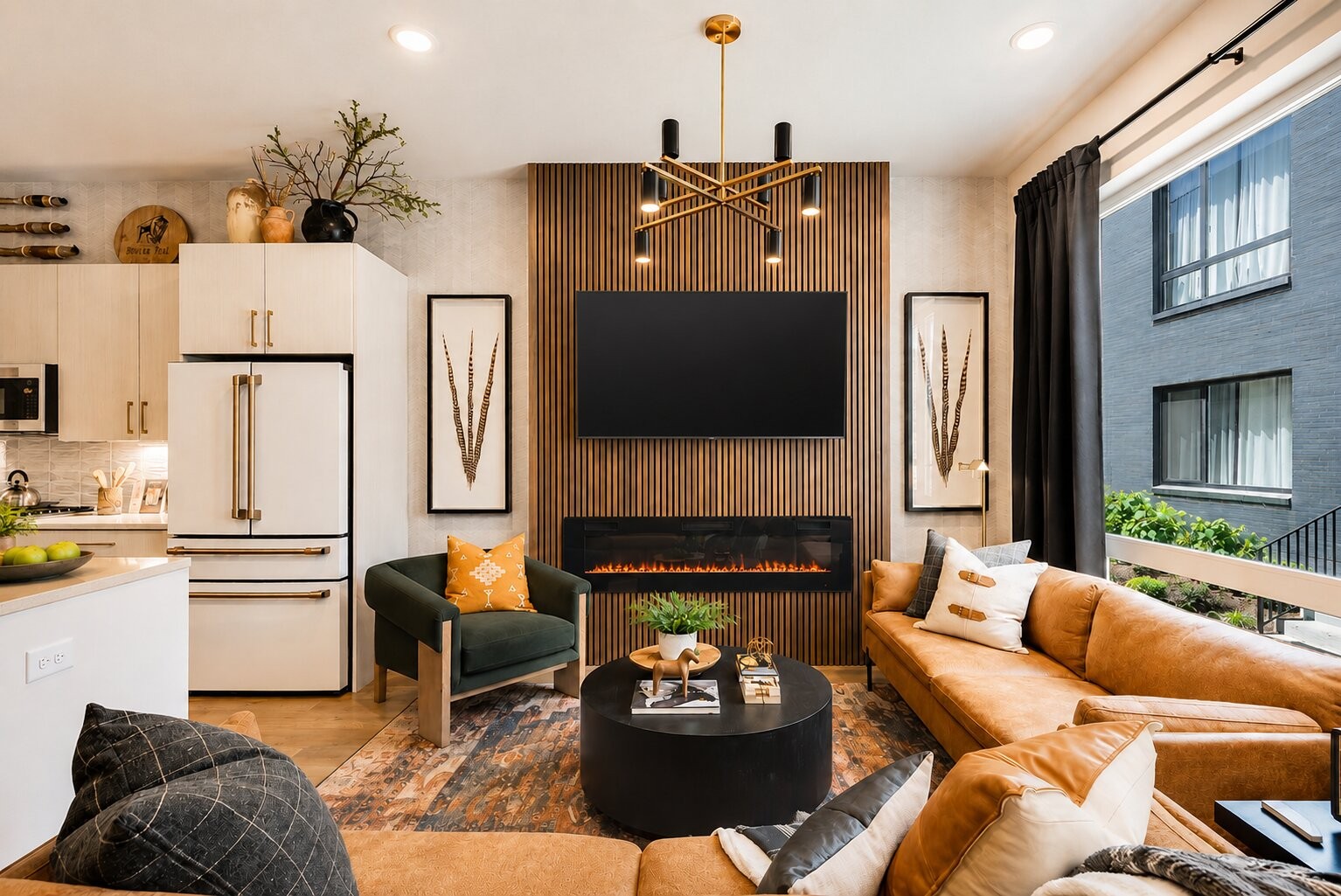 Open-plan living room and kitchen with leather seating and a TV above a linear fireplace on a wood-slat wall.