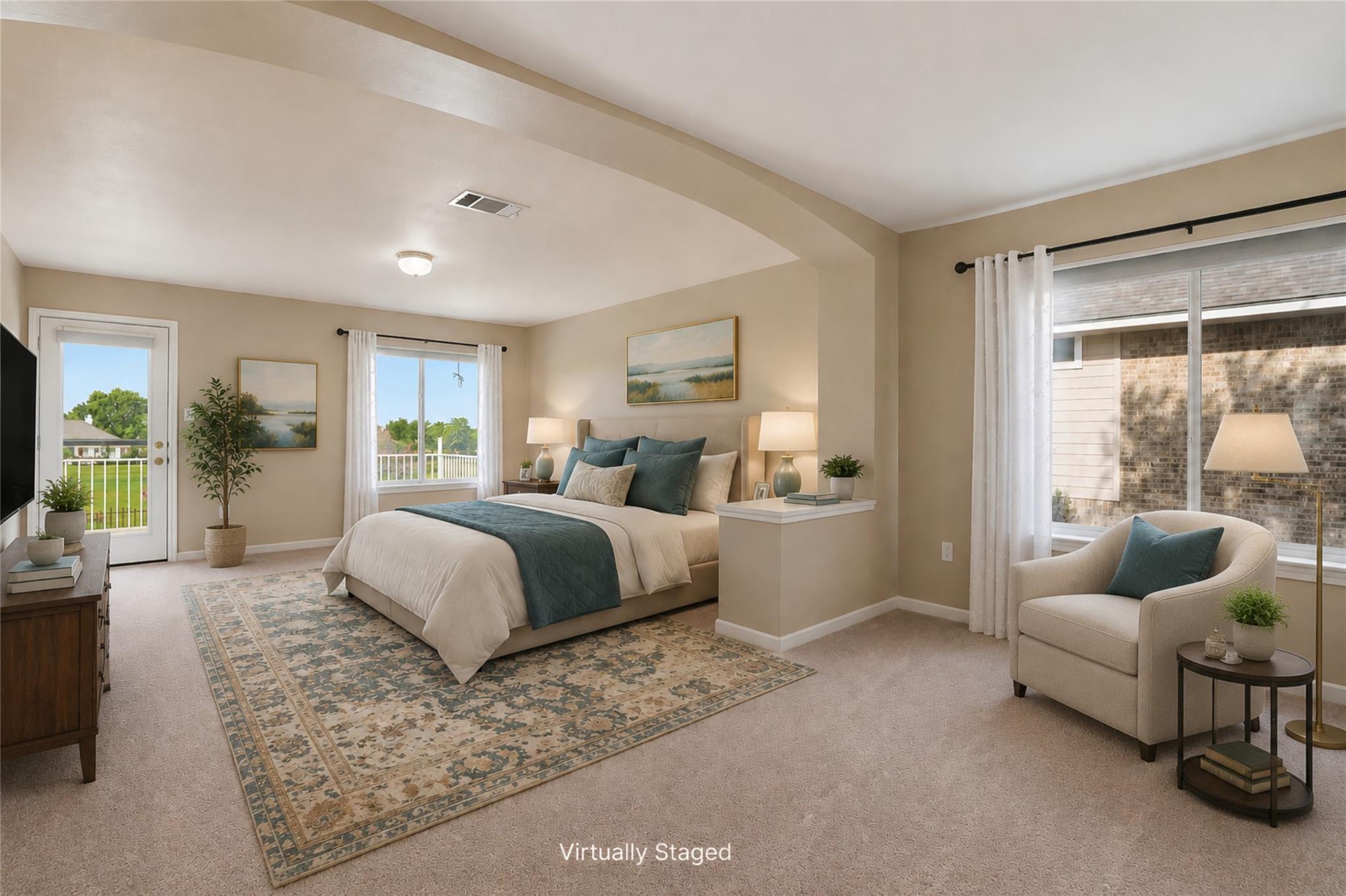 Virtually staged bedroom with a king bed, teal bedding, patterned rug, and window-side sitting area.