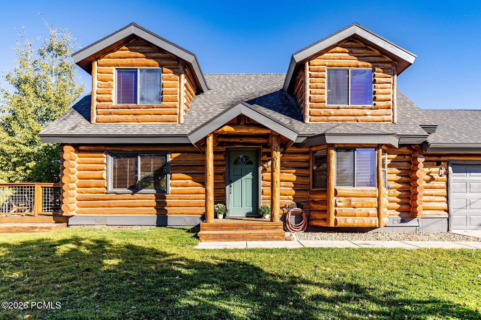 Log cabin-style home with twin dormers and a covered front entry.