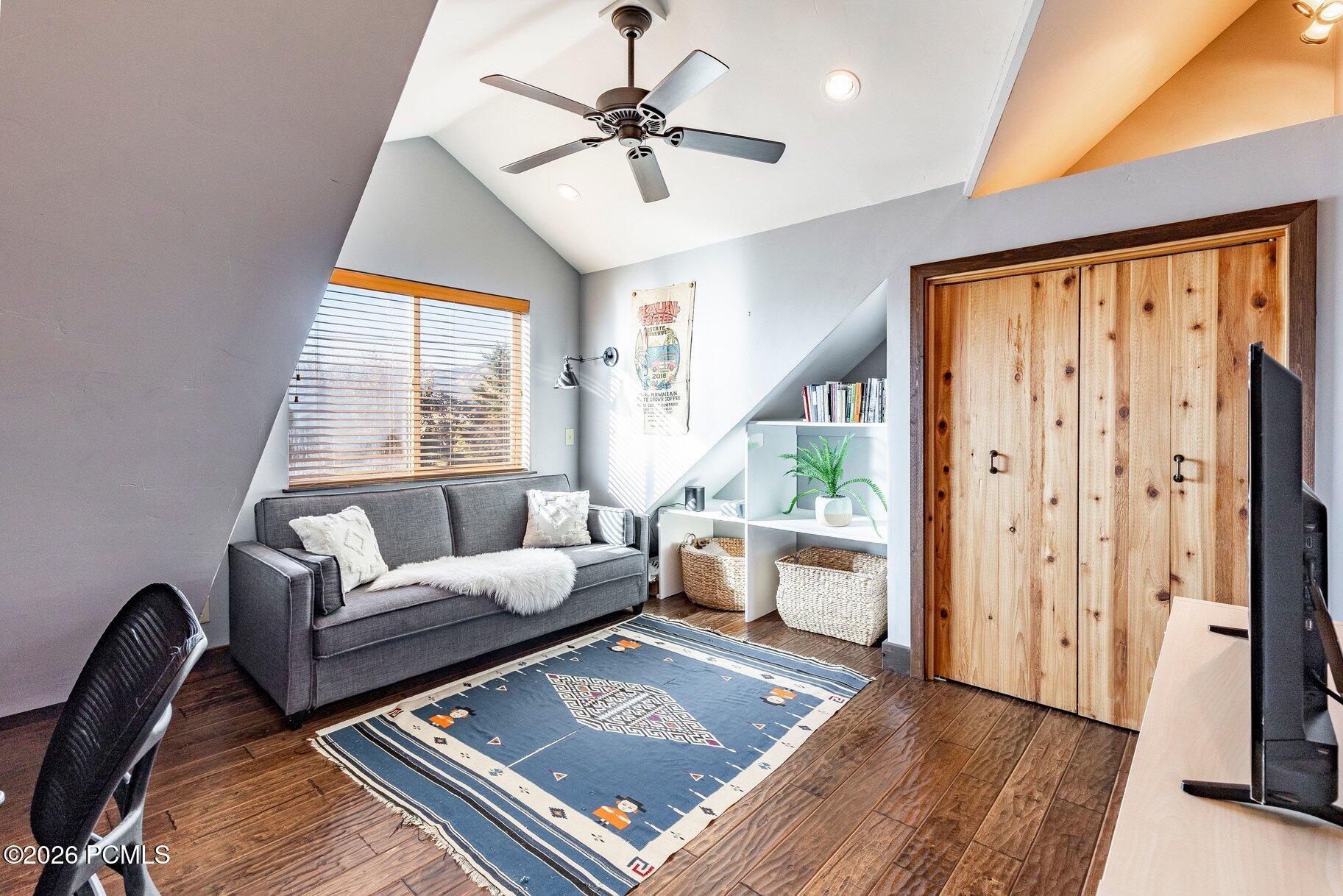 Furnished living room with a gray sofa, patterned rug, built-in shelves, and wooden sliding doors.
