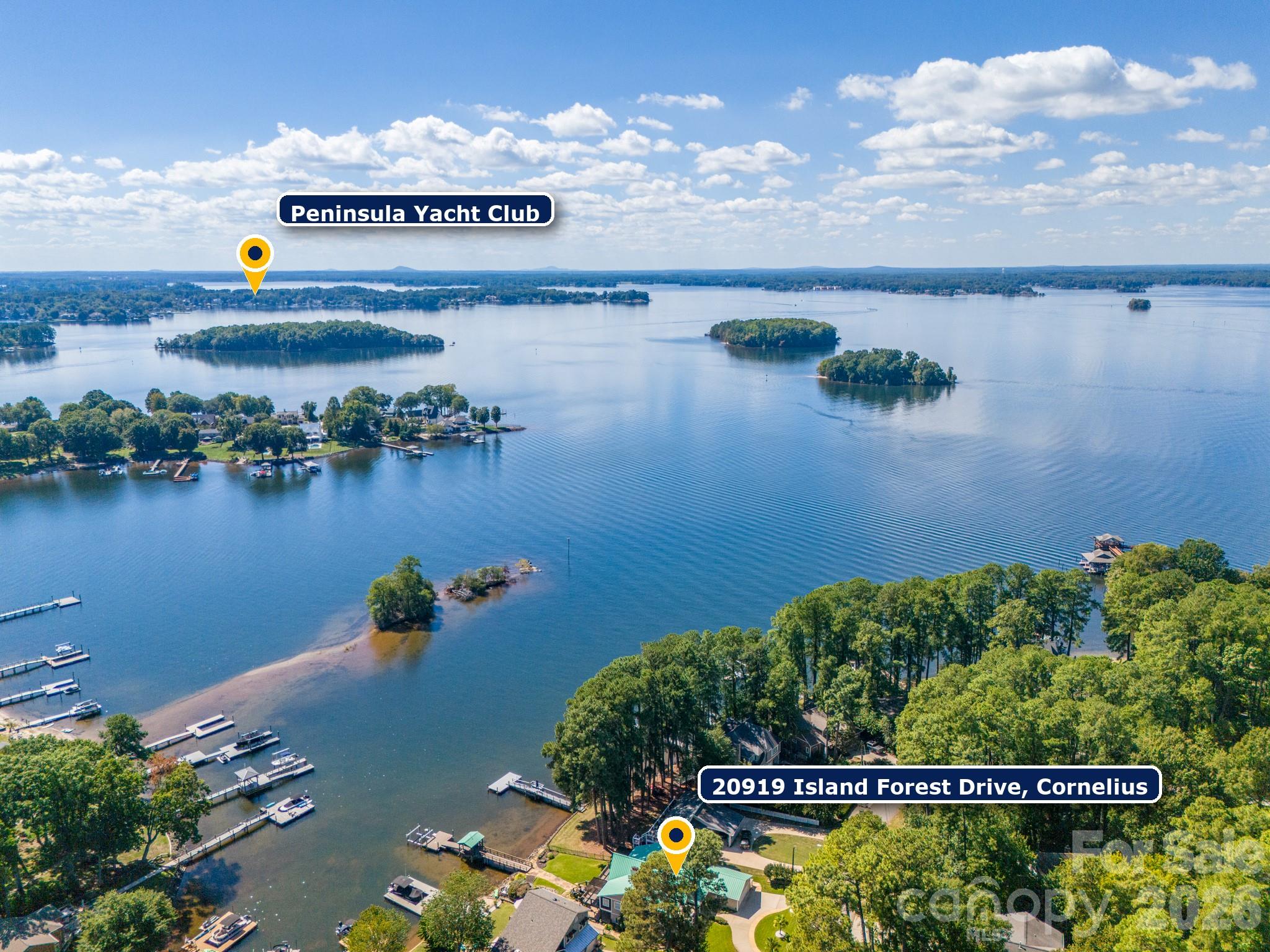 Aerial view of 20919 Island Forest Drive beside the lake, with wooded shoreline, docks, and islands.