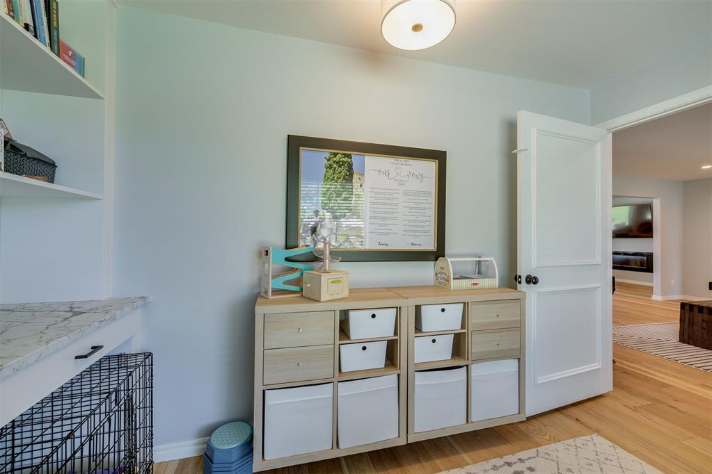 Storage area with pale blue walls, white bins, built-in shelves, and a black wire dog crate.
