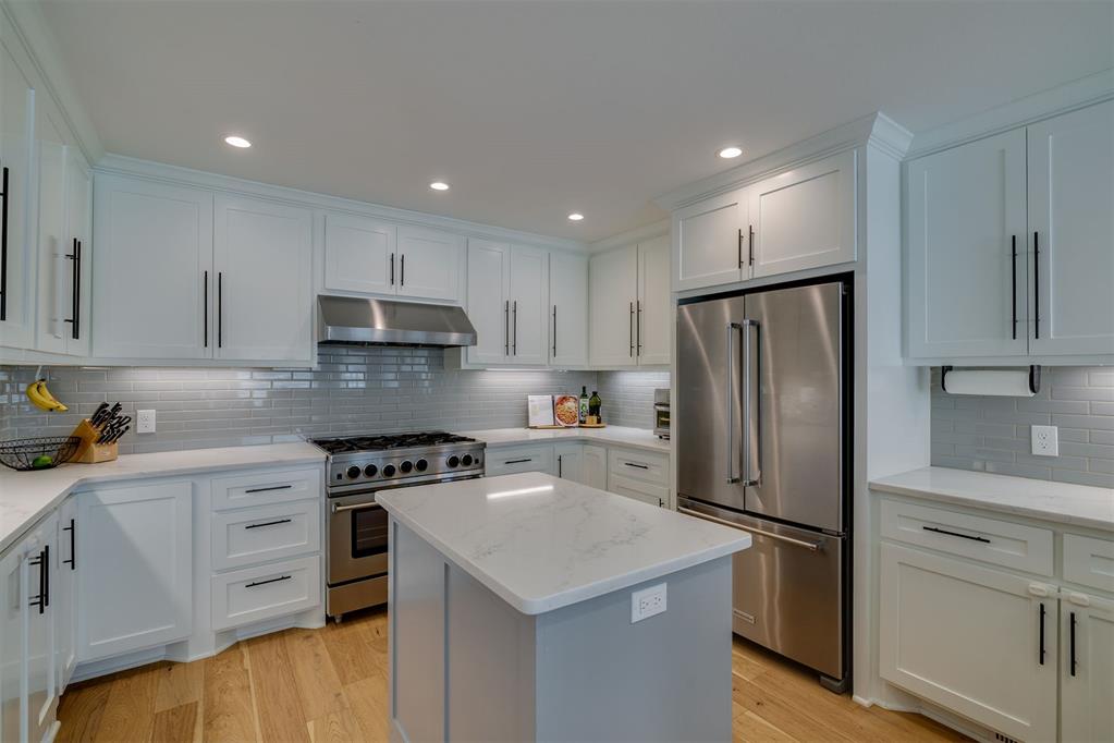 Kitchen with white shaker cabinets, stainless steel appliances, and a central island.