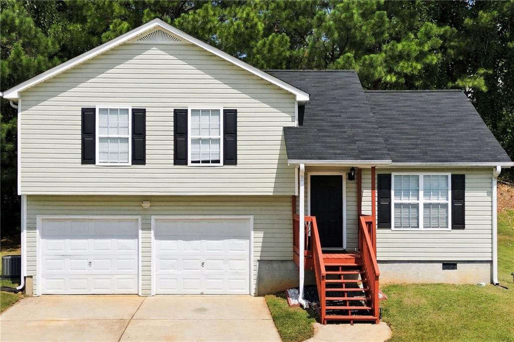 Beige two-story house with a two-car garage and red front steps.