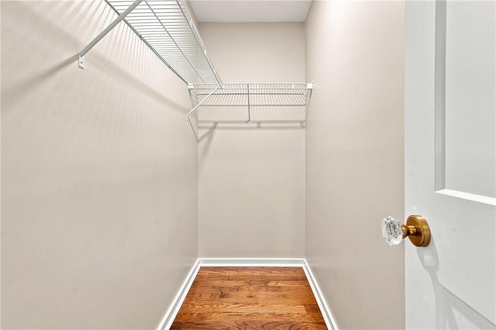 Walk-in closet with white wire shelving and a hardwood floor.