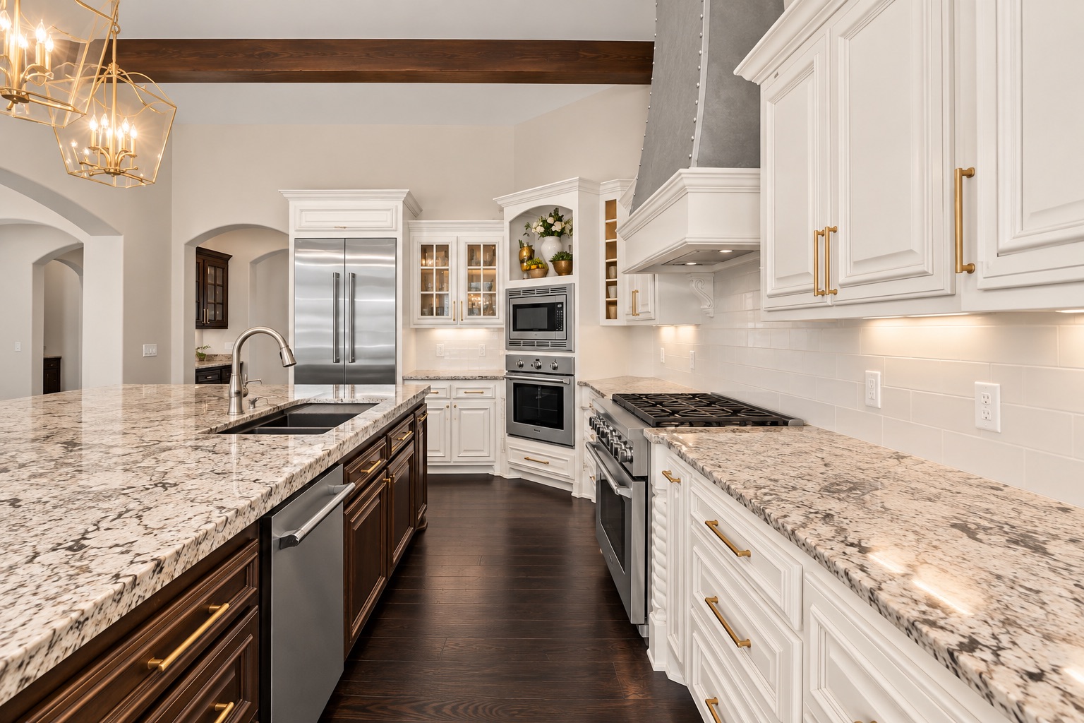Kitchen with granite counters, white cabinetry, stainless steel appliances, and a dark wood island.