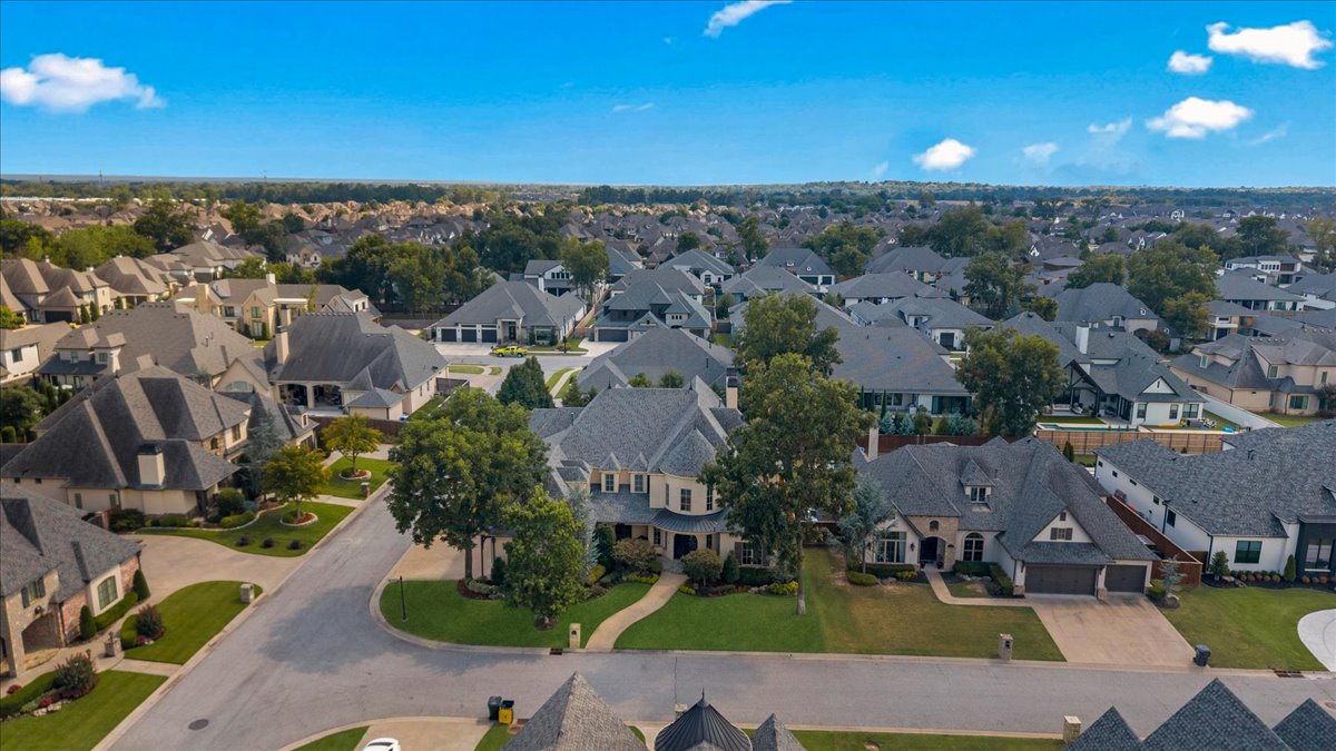 Aerial view of a suburban neighborhood with tree-lined streets and rows of detached homes.