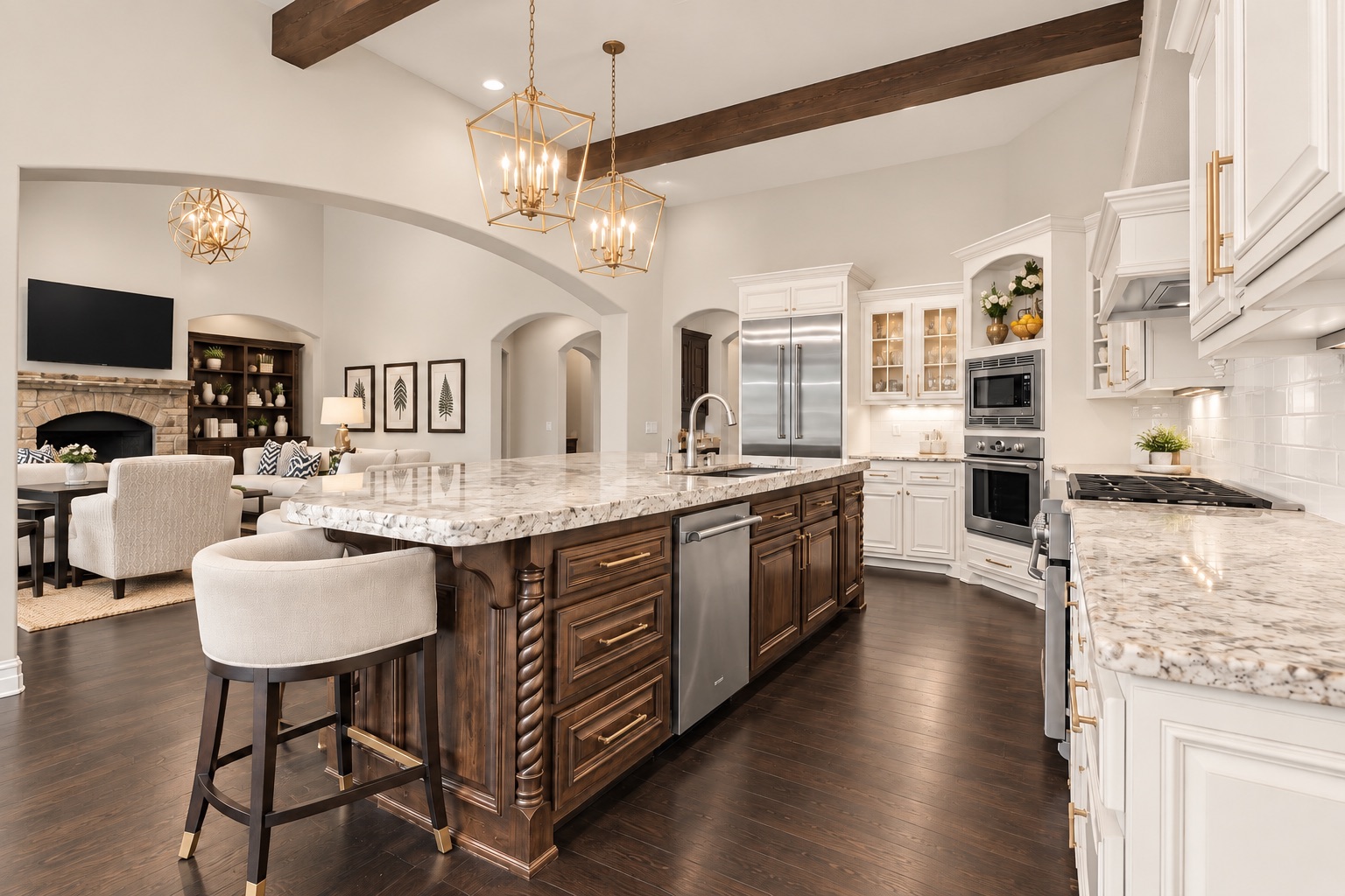 Open kitchen with a dark wood island, veined stone counters, white cabinets, and adjoining stone fireplace.