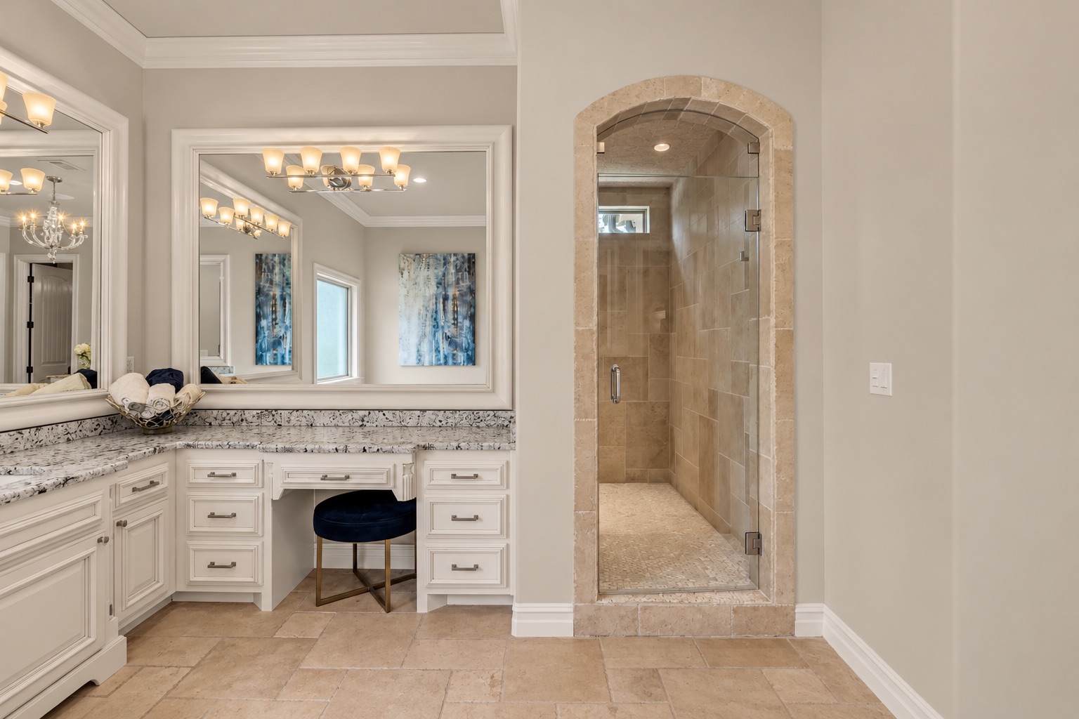 Bathroom with a white vanity and an arched, tan-tiled walk-in shower.