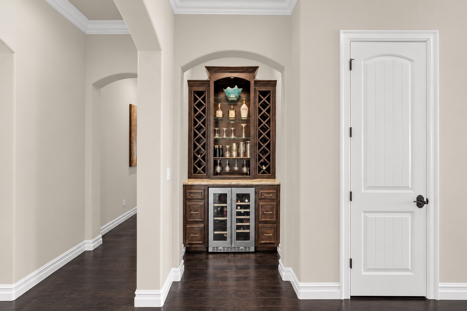 Built-in wine bar with dark wood cabinets, glassware, and dual wine refrigerators.