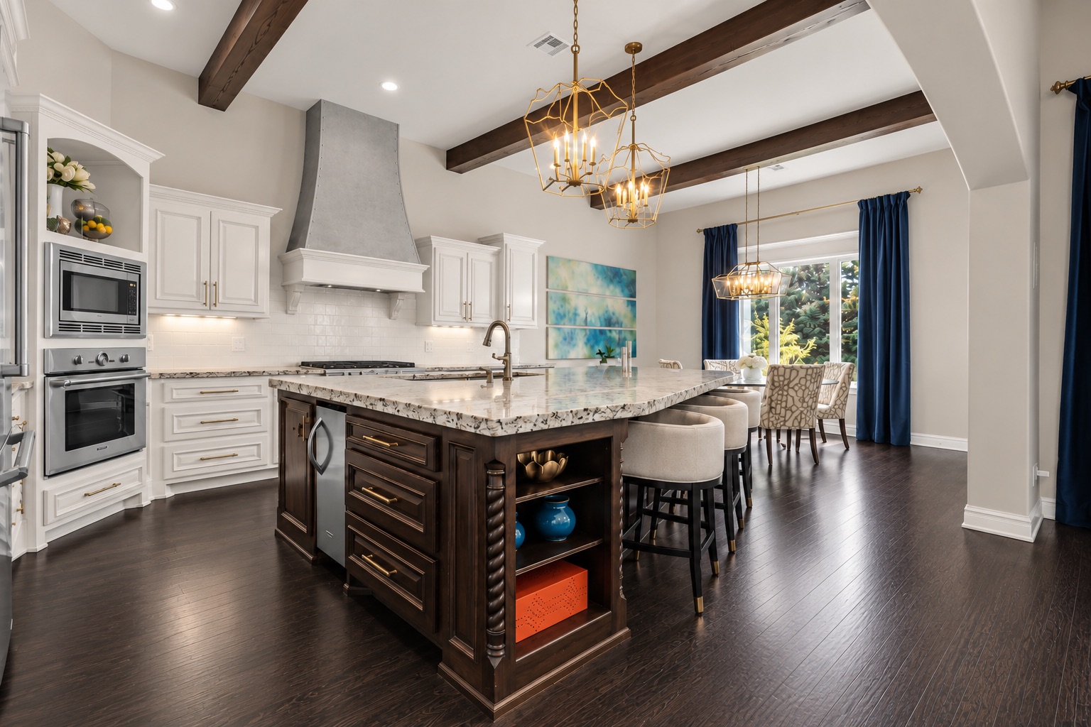 Kitchen with a large dark wood island, pale stone countertop, and exposed ceiling beams.