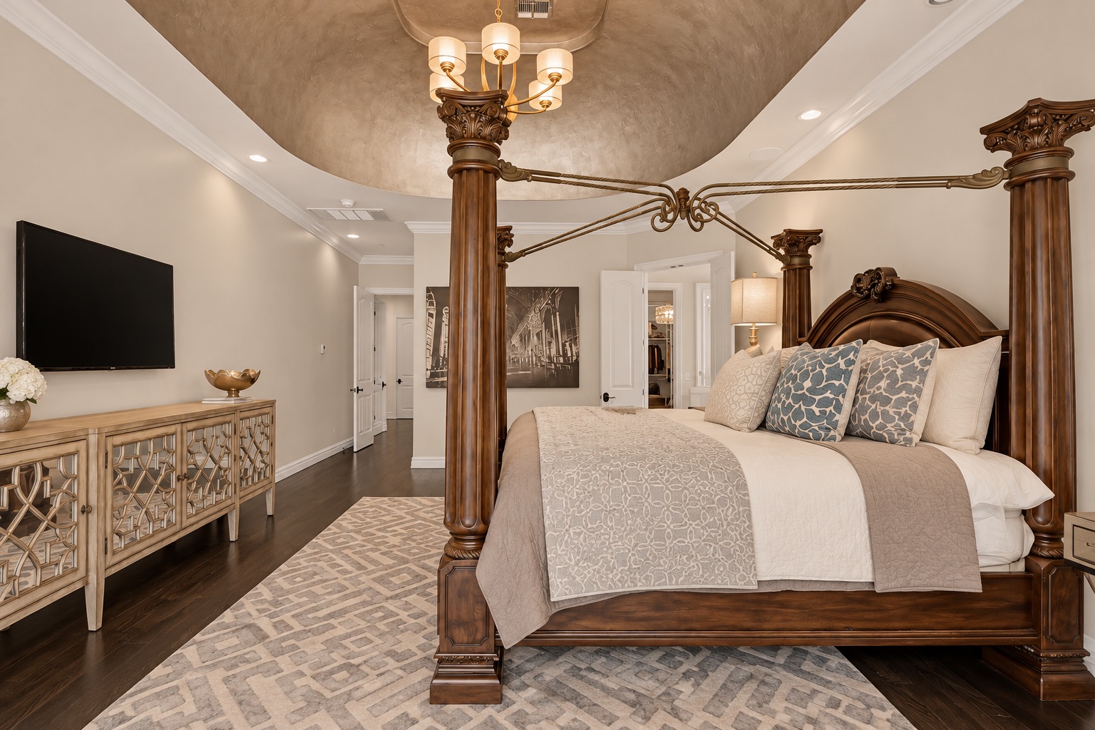 Bedroom with an ornate dark wood four-poster bed, patterned bedding, and a chandelier.