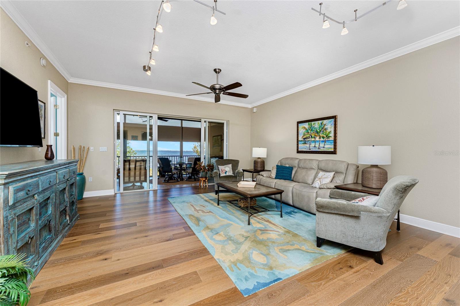 Living room with wood floors and sliding glass doors overlooking the water.