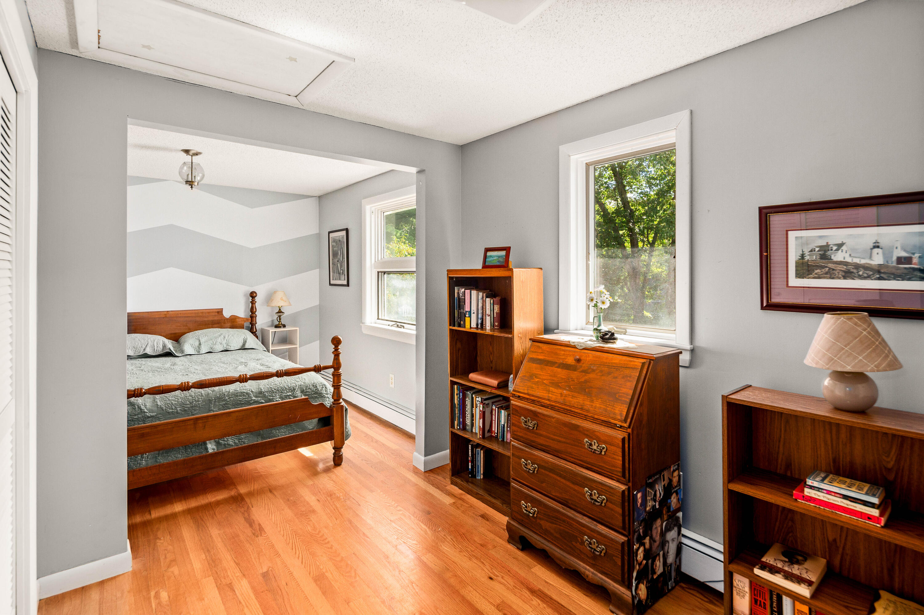 Bedroom with a wooden four-poster bed, hardwood floors, and antique furniture.