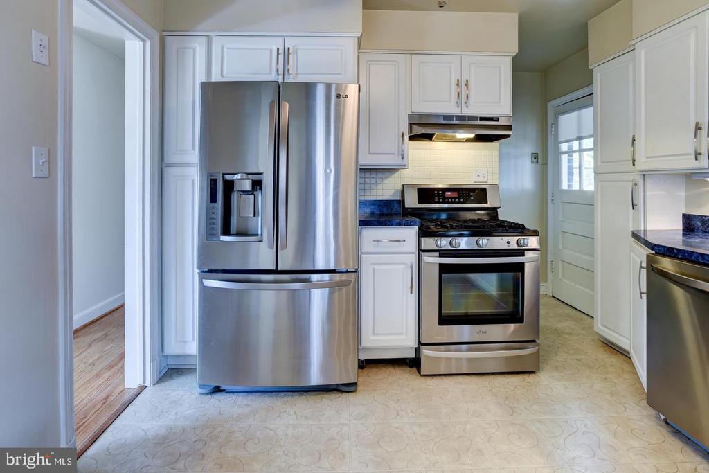 Kitchen with white cabinets, stainless steel appliances, and blue countertops.